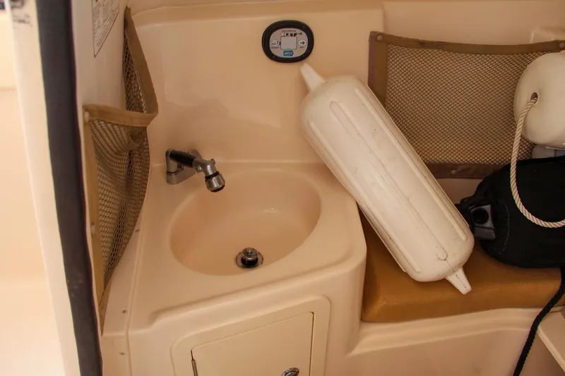 Slide: The Image of 2014 Grady-White Freedom 307 boat interior with sink and storage compartments. - 43