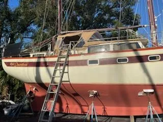 Slide: The Image of 1978 Islander Freeport 41 Ketch sailboat on stands, ladder leaning against hull. - 11