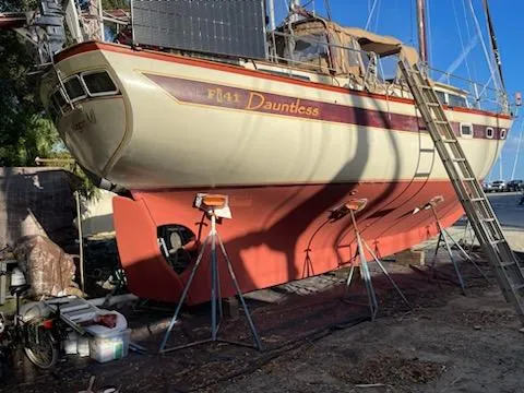 Slide: The Image of 1978 Islander Freeport 41 Ketch sailboat, named Dauntless, on dry dock for maintenance. - 12