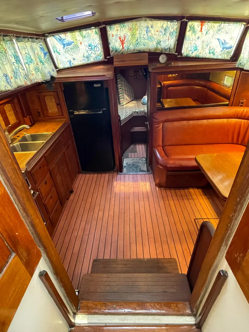 Slide: The Image of 1978 Islander Freeport 41 Ketch interior with wood finish, kitchen, and seating area. - 18