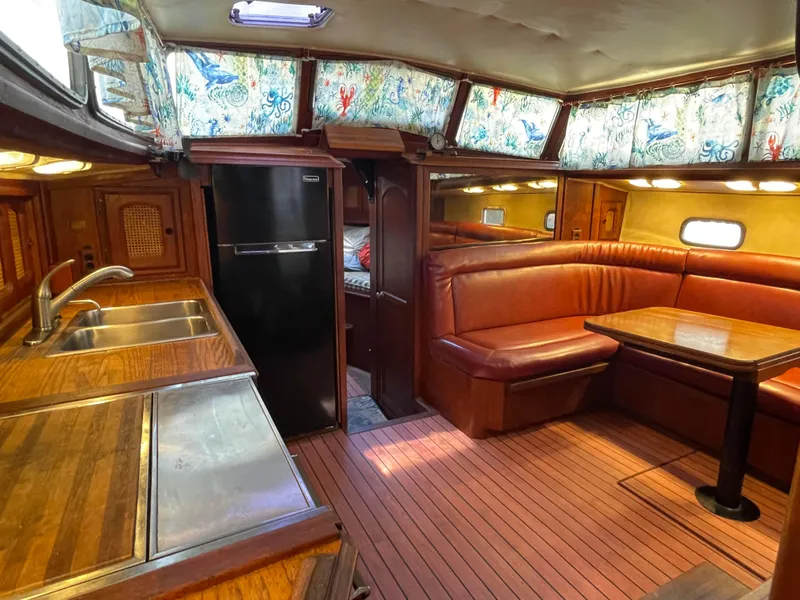 Slide: The Image of 1978 Islander Freeport 41 Ketch interior with wood finishes, kitchen, and dining area. - 19