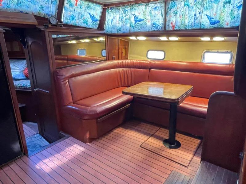 Slide: The Image of Interior of 1978 Islander Freeport 41 Ketch with red leather seating and wooden table. - 20