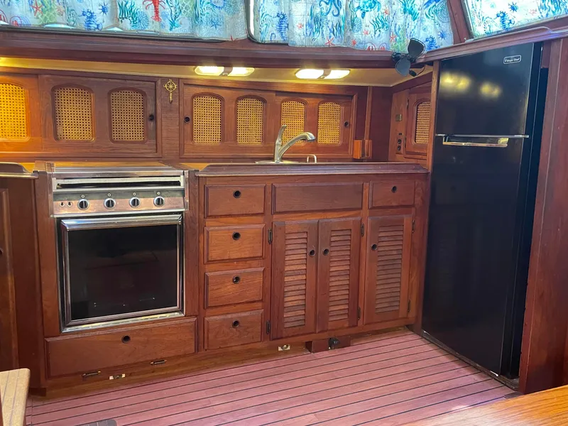 Slide: The Image of 1978 Islander Freeport 41 Ketch kitchen with wood cabinetry, stove, and refrigerator. - 23