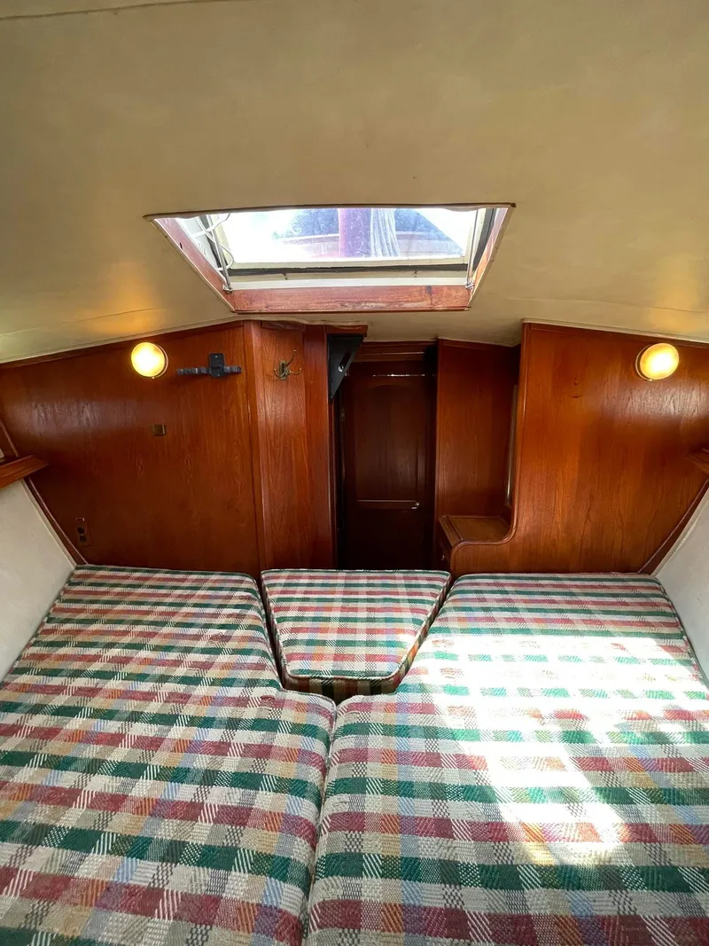 Slide: The Image of Interior cabin of 1978 Islander Freeport 41 Ketch with plaid bedding and wooden walls. - 27