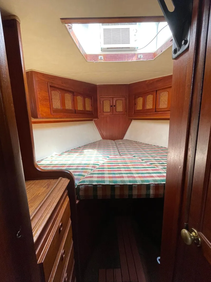 Slide: The Image of Cozy cabin interior of 1978 Islander Freeport 41 Ketch with wood paneling and striped bedding. - 28