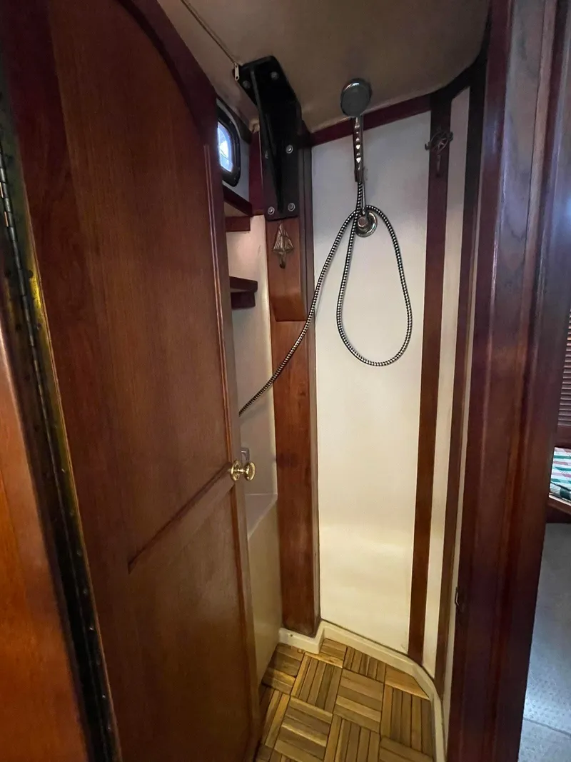 Slide: The Image of 1978 Islander Freeport 41 Ketch shower with wooden accents and handheld showerhead. - 32