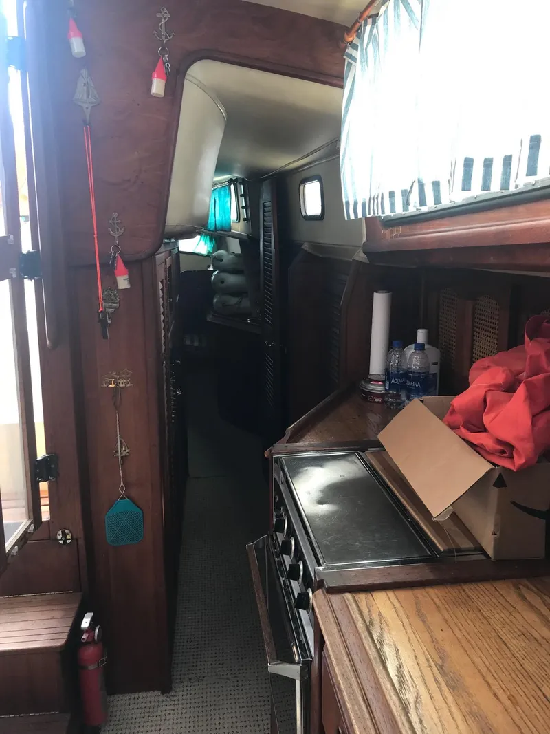 Slide: The Image of Interior of 1978 Islander Freeport 41 Ketch, featuring wood cabinetry and compact kitchen. - 33