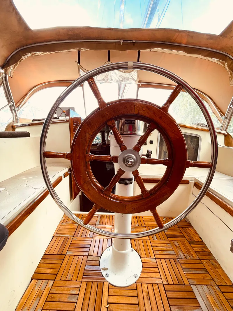 Slide: The Image of Wooden helm of 1978 Islander Freeport 41 Ketch sailboat, teak deck, enclosed cockpit. - 34