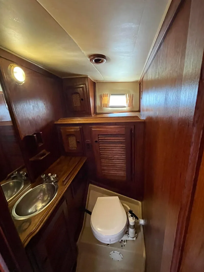 Slide: The Image of 1978 Islander Freeport 41 Ketch bathroom with wooden cabinetry and compact design. - 41