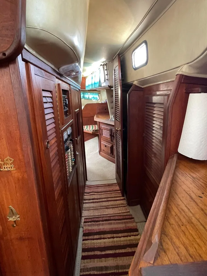 Slide: The Image of 1978 Islander Freeport 41 Ketch interior with wooden cabinetry and cozy hallway. - 43