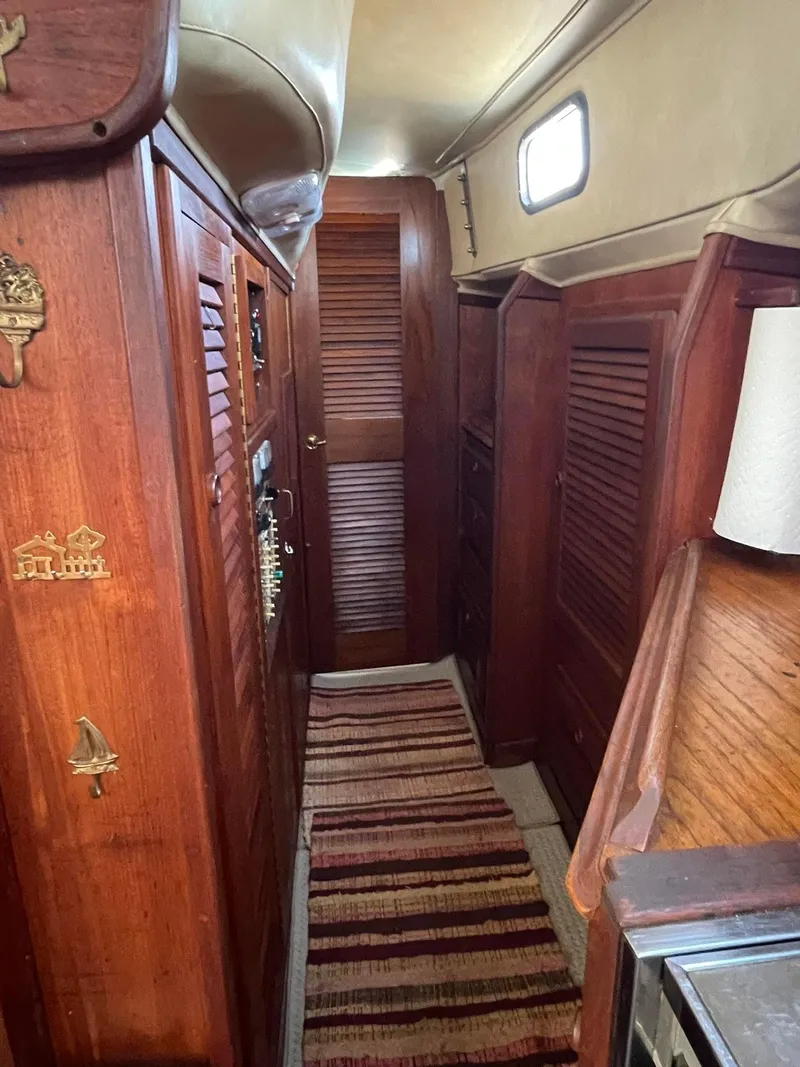 Slide: The Image of 1978 Islander Freeport 41 Ketch interior with wooden cabinetry and striped rug. - 44