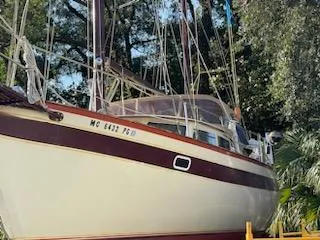 Slide: The Image of 1978 Islander Freeport 41 Ketch sailboat docked among trees. - 7