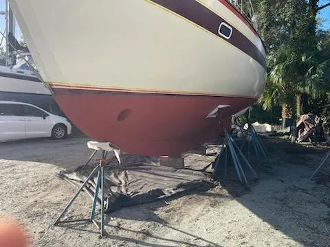 Slide: The Image of 1978 Islander Freeport 41 Ketch on stands, hull view in a sunny boatyard. - 8