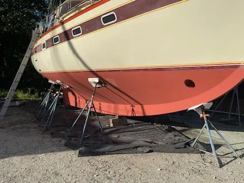 Slide: The Image of 1978 Islander Freeport 41 Ketch sailboat on stands for maintenance. - 9