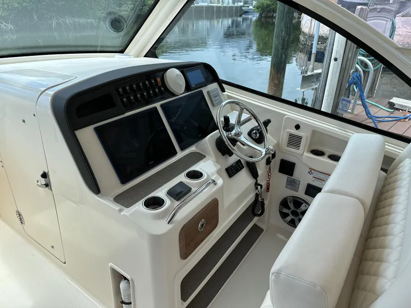 Slide: The Image of 2017 Grady-White Freedom 375 helm with dual screens and steering wheel, dockside view. - 13