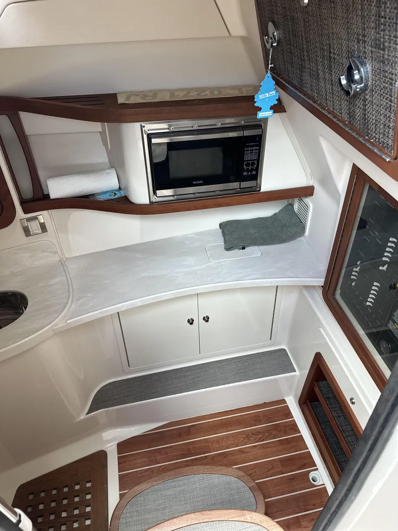 Slide: The Image of 2017 Grady-White Freedom 375 cabin interior with microwave and wood accents. - 17