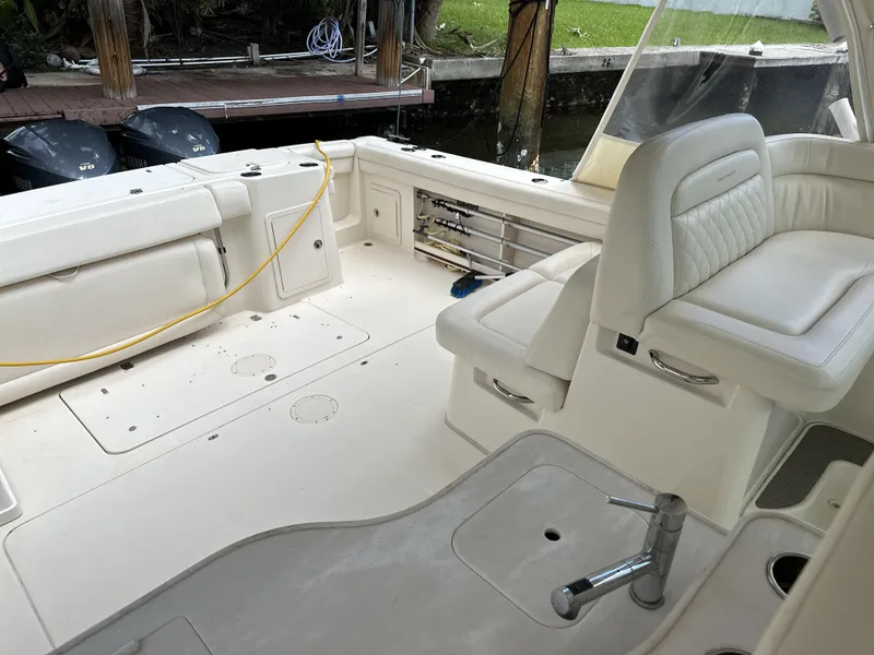 Slide: The Image of 2017 Grady-White Freedom 375 boat interior with white seating and deck, docked by water. - 24
