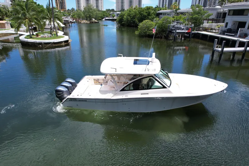 Slide: The Image of 2017 Grady-White Freedom 375 boat cruising on a scenic waterway with lush greenery. - 6