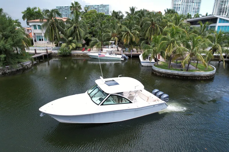 Slide: The Image of 2017 Grady-White Freedom 375 boat cruising in a tropical marina setting. - 9