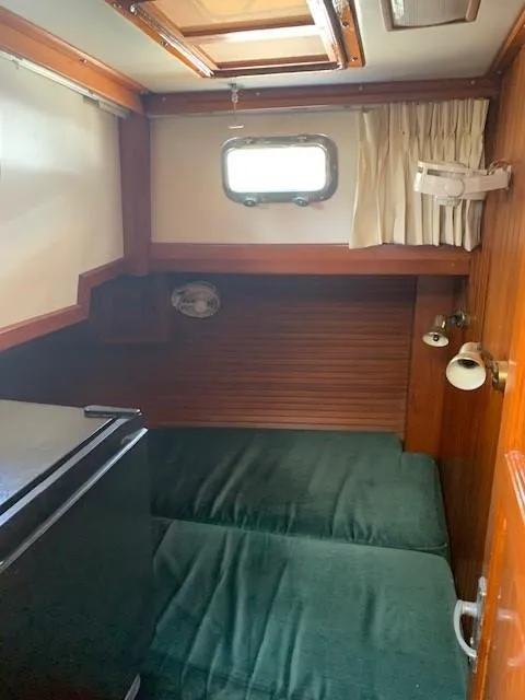 Slide: The Image of 1988 Slocum 43 yacht cabin with wood paneling and green bedding. - 17