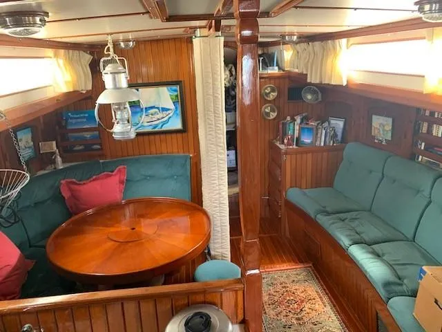 Slide: The Image of Cozy 1988 Slocum 43 yacht interior with wood paneling, teal seating, and nautical decor. - 27