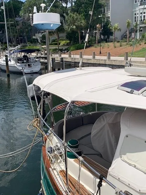 Slide: The Image of 1988 Slocum 43 sailboat docked in a marina, featuring a white canopy and wooden accents. - 29