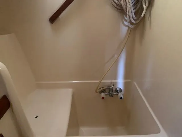 Slide: The Image of Slocum 43 sailboat interior shower with faucet and coiled rope, 1988 model. - 30