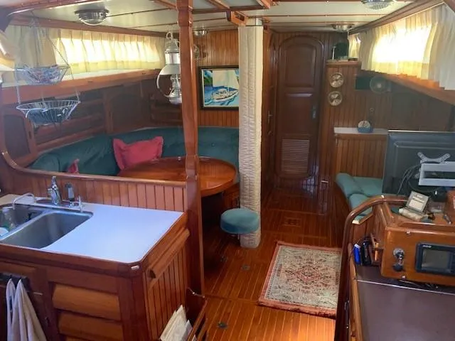 Slide: The Image of Interior of 1988 Slocum 43 sailboat with wood paneling and cozy seating area. - 32