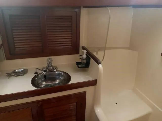 Slide: The Image of 1988 Slocum 43 yacht bathroom with sink, shower, and wooden cabinets. - 34