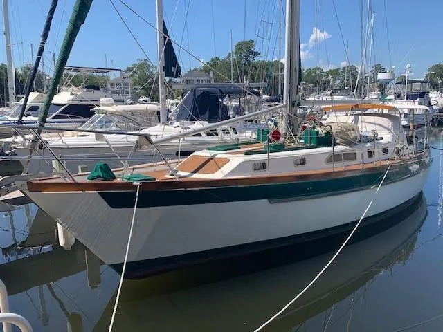 Slide: The Image of 1988 Slocum 43 sailboat docked in a marina, surrounded by other boats. - 38