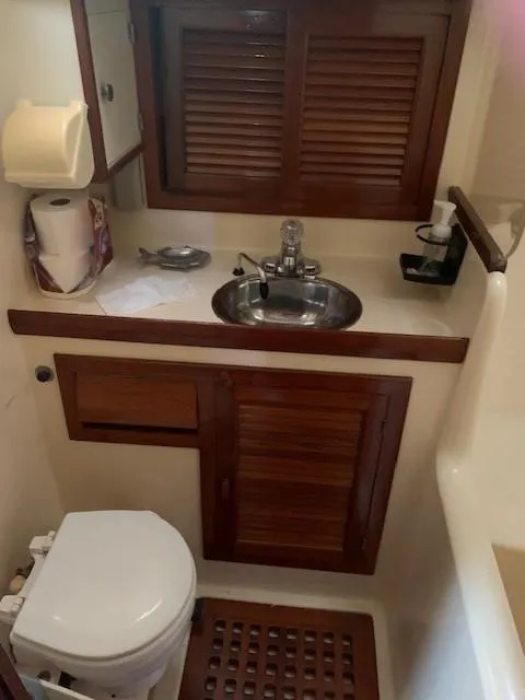 Slide: The Image of 1988 Slocum 43 yacht bathroom with wooden cabinets and stainless steel sink. - 39