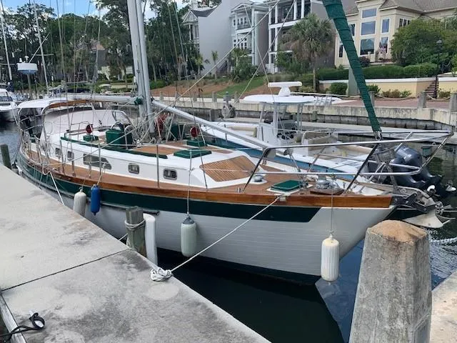 Slide: The Image of 1988 Slocum 43 sailboat docked in a marina, surrounded by residential buildings. - 4