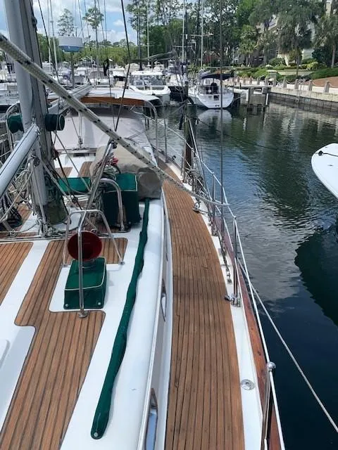 Slide: The Image of 1988 Slocum 43 sailboat docked in a marina, featuring a wooden deck and rigging. - 8