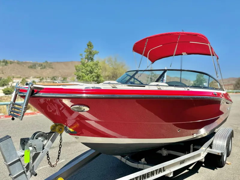 Slide: The Image of Red 2013 Monterey 214 SS boat on trailer with canopy, parked outdoors. - 3
