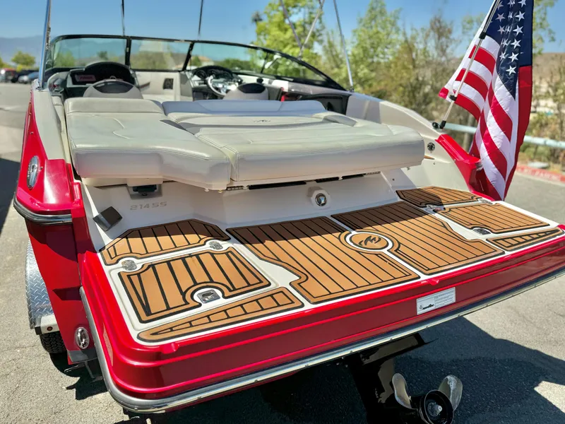 Slide: The Image of 2013 Monterey 214 SS boat with American flag, featuring teak-style swim platform. - 6