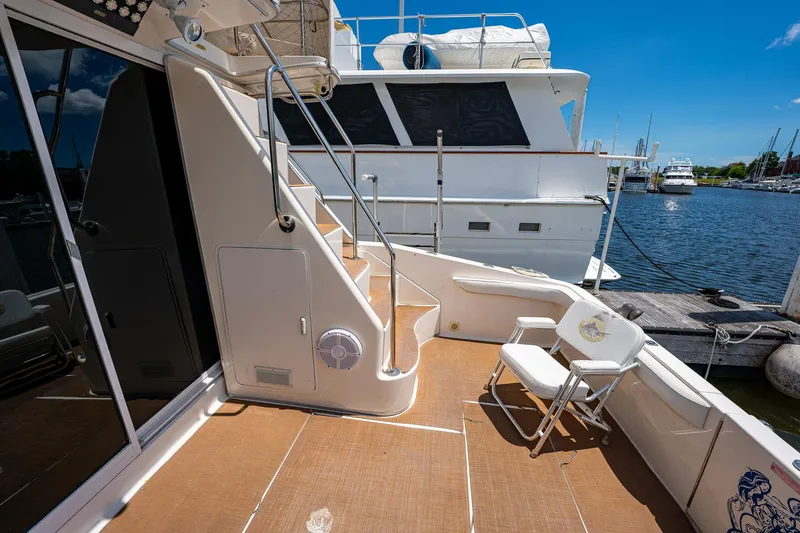 Slide: The Image of 1995 Sea Ray 550 Sedan Bridge yacht deck with seating, docked at marina. - 10