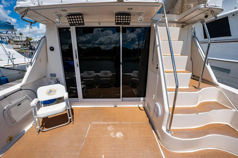 Slide: The Image of 1995 Sea Ray 550 Sedan Bridge yacht deck with stairs and seating area. - 11