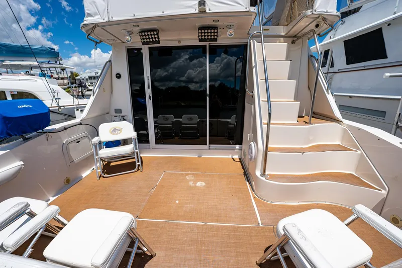 Slide: The Image of 1995 Sea Ray 550 Sedan Bridge yacht deck with seating and stairs. - 12