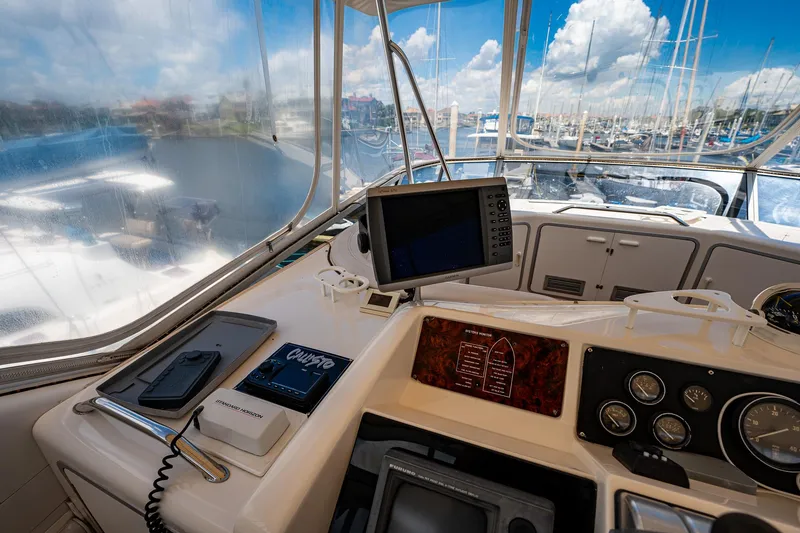 Slide: The Image of 1995 Sea Ray 550 Sedan Bridge helm with navigation equipment and marina view. - 19