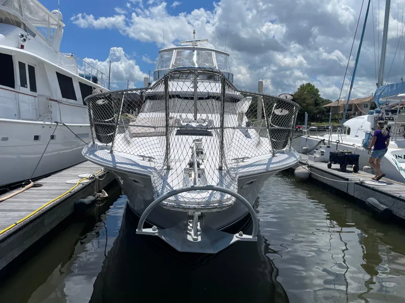 Slide: The Image of 1995 Sea Ray 550 Sedan Bridge yacht docked at marina under cloudy sky. - 2