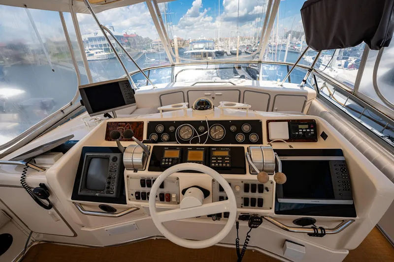 Slide: The Image of 1995 Sea Ray 550 Sedan Bridge helm with navigation instruments and marina view. - 20