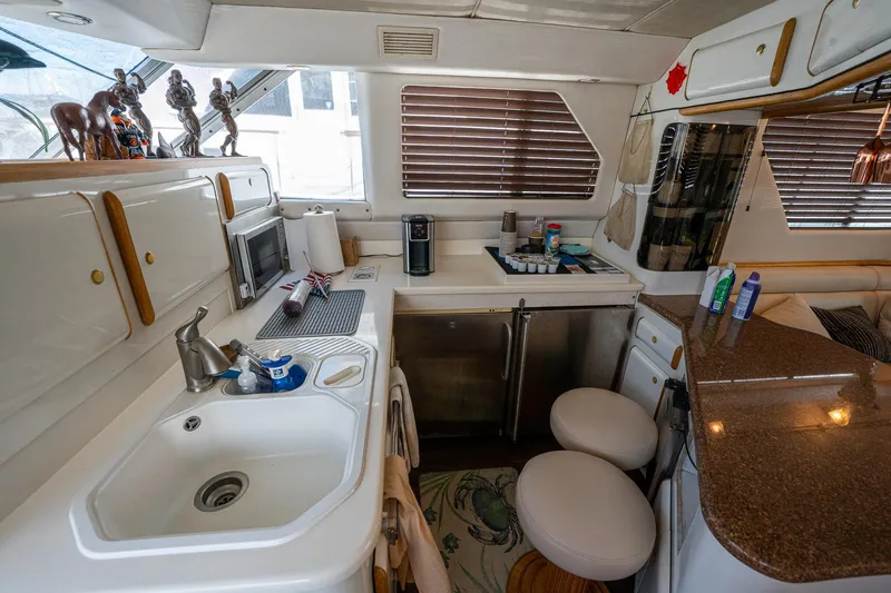 Slide: The Image of Interior of 1995 Sea Ray 550 Sedan Bridge yacht kitchen with modern amenities. - 25