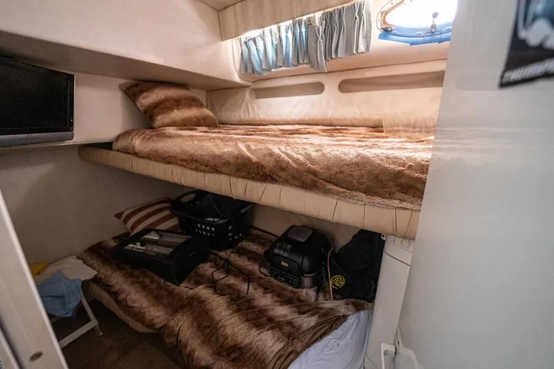 Slide: The Image of Cozy cabin interior of 1995 Sea Ray 550 Sedan Bridge with bunk beds and storage. - 26