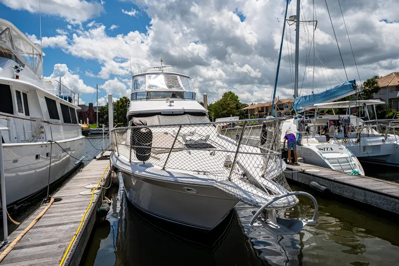 Slide: The Image of 1995 Sea Ray 550 Sedan Bridge yacht docked at marina under cloudy sky. - 3