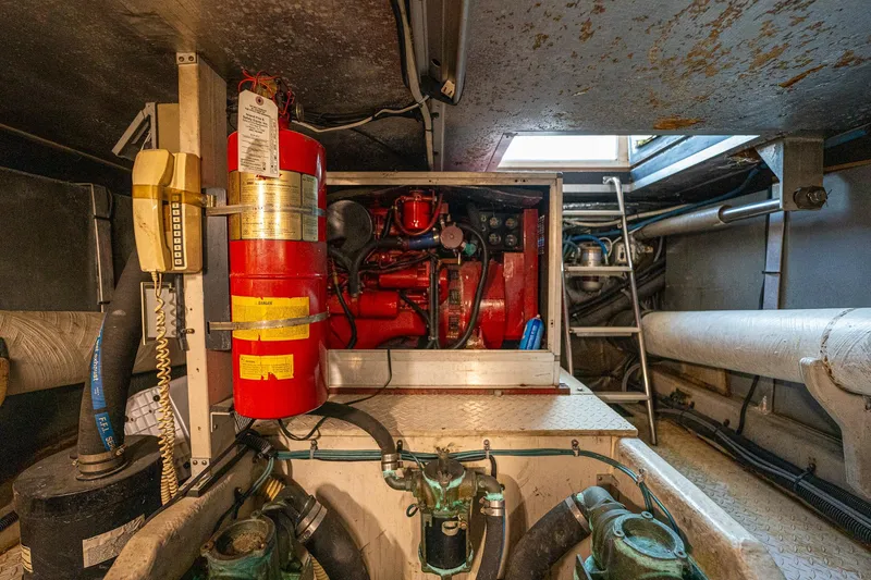 Slide: The Image of Engine room of 1995 Sea Ray 550 Sedan Bridge with fire extinguisher and equipment. - 32