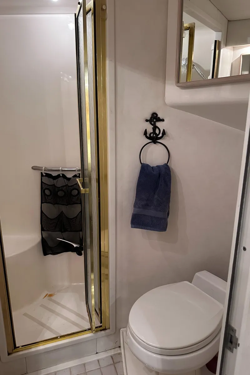 Slide: The Image of Bathroom interior of 1995 Sea Ray 550 Sedan Bridge yacht, featuring shower and toilet. - 49