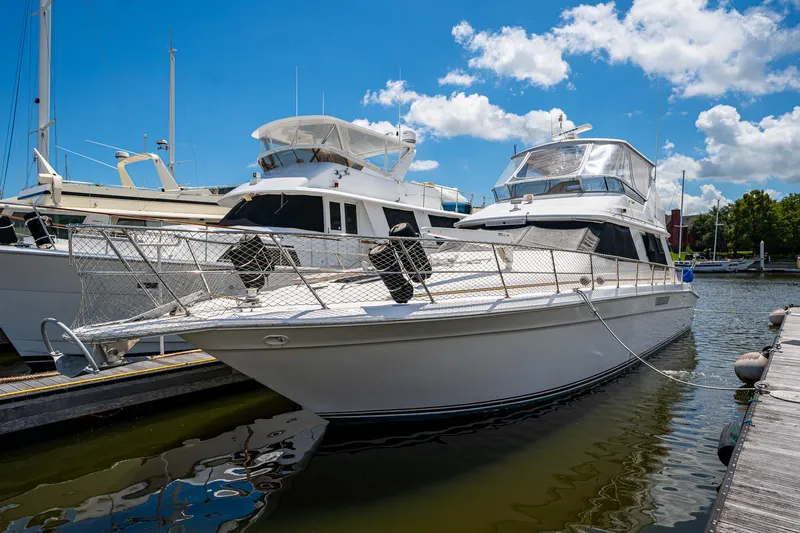 Slide: The Image of 1995 Sea Ray 550 Sedan Bridge yacht docked at marina under blue sky. - 5