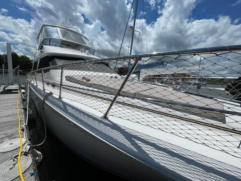 Slide: The Image of 1995 Sea Ray 550 Sedan Bridge yacht docked under cloudy sky. - 8