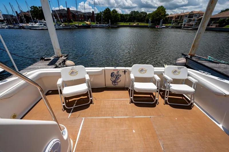 Slide: The Image of 1995 Sea Ray 550 Sedan Bridge yacht deck with chairs overlooking marina. - 9