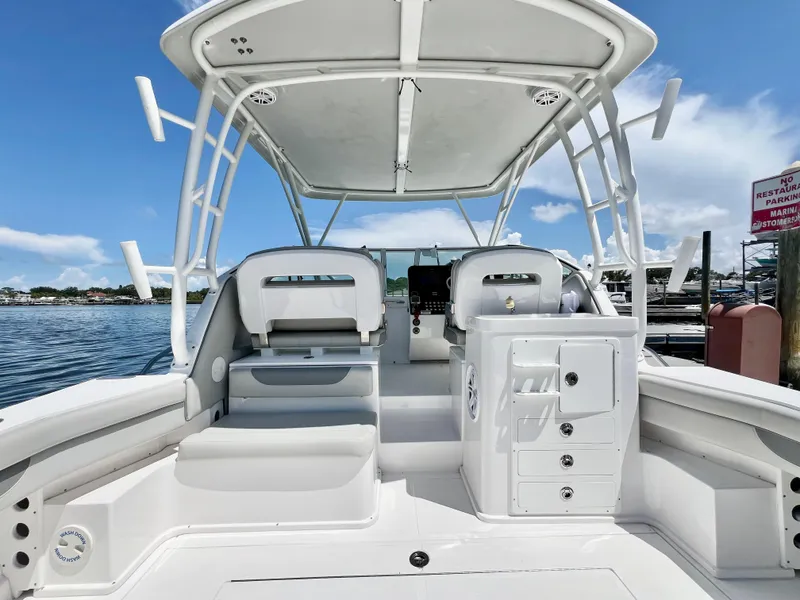 Slide: The Image of 2022 Stamas 326 Aegean boat interior with seating and helm, docked by the water. - 10